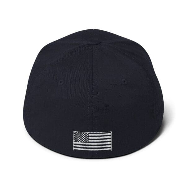 The back of a navy 6277 Flexfit Cap w/ White Logo with an american flag on it.