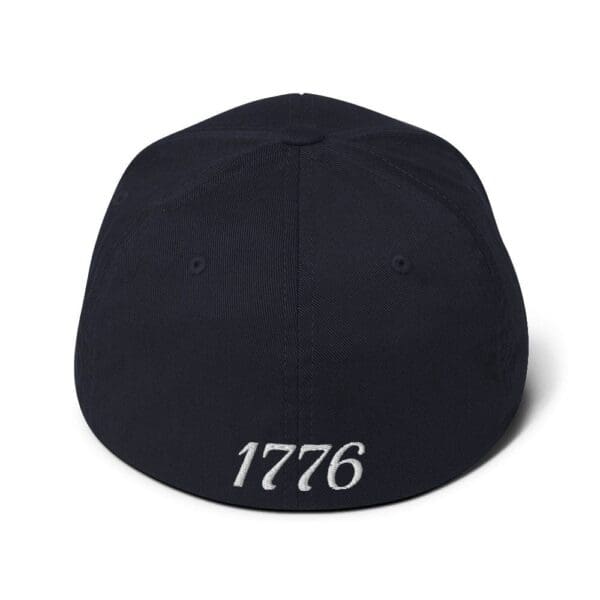 A navy 6277 Flexfit Cap Citizens Army w/ Flag (White Font) hat with the word 1776 on it.